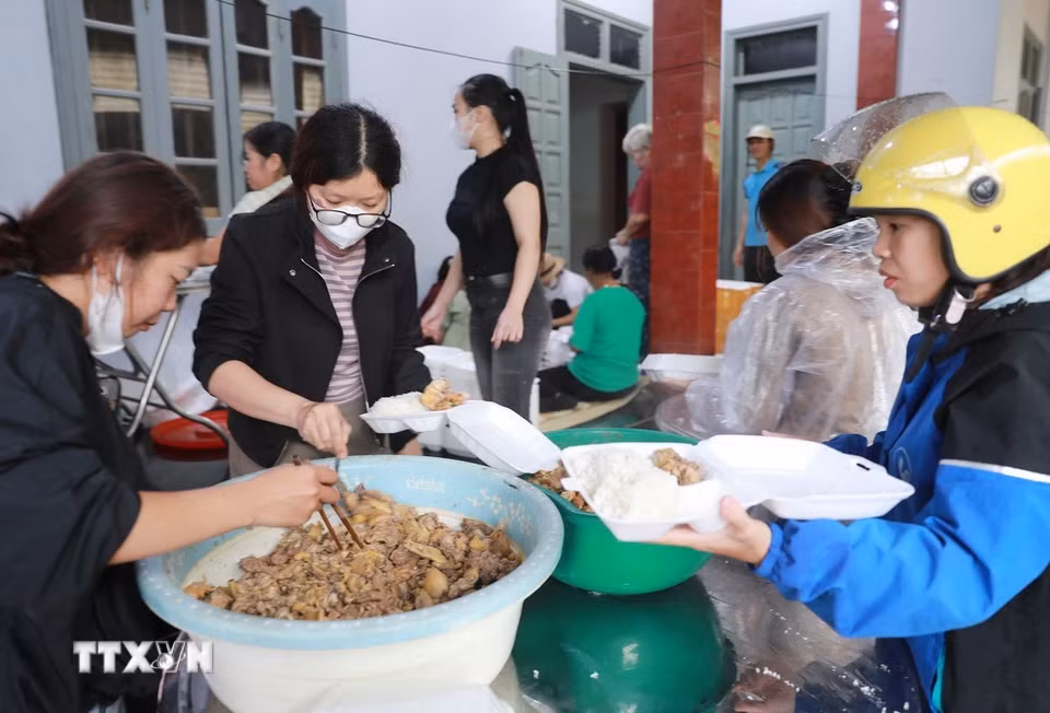 Nhân dân Bản Phúc Khoa, Không ai bảo ai, chia nhau mỗi người một việc để có những suất cơm đến sớm nhất vùng rốn lũ. (Ảnh: Quý Trung/TTXVN)