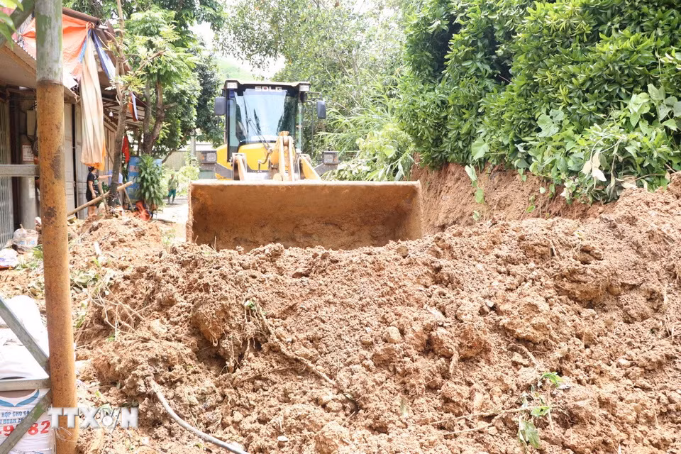 Các đơn vị giao thông thu dọn khu vực bị sạt lở để thông tuyến tại tỉnh lộ 137 qua địa bàn xã Nậm Mạ. (Ảnh: Nguyễn Oanh/TTXVN)