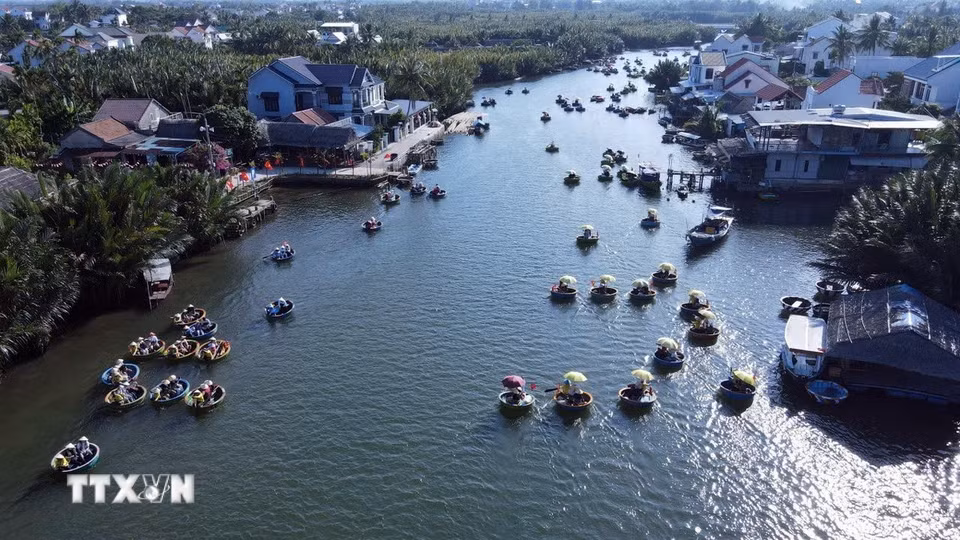 Du khách lênh đênh trên những chiếc thuyền thúng nhỏ khám phá làng dừa Cẩm Thanh, một trong 50 ngôi làng đẹp nhất thế giới năm 2025. (Ảnh: Đỗ Trưởng/TTXVN)