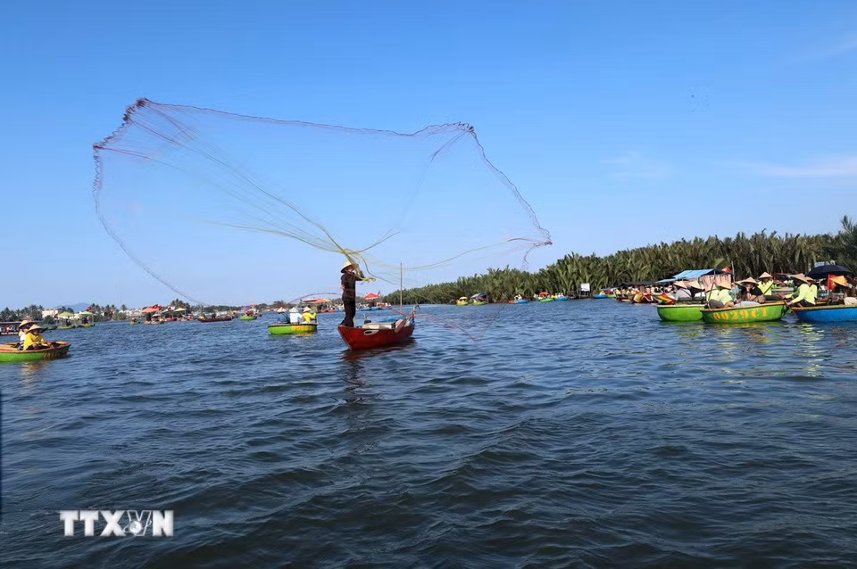 Người dân địa phương tái hiện cảnh quăng chài đánh cá để phục vụ du khách ở làng dừa Cẩm Thanh, một trong 50 ngôi làng đẹp nhất thế giới năm 2025. (Ảnh: Đỗ Trưởng/TTXVN)