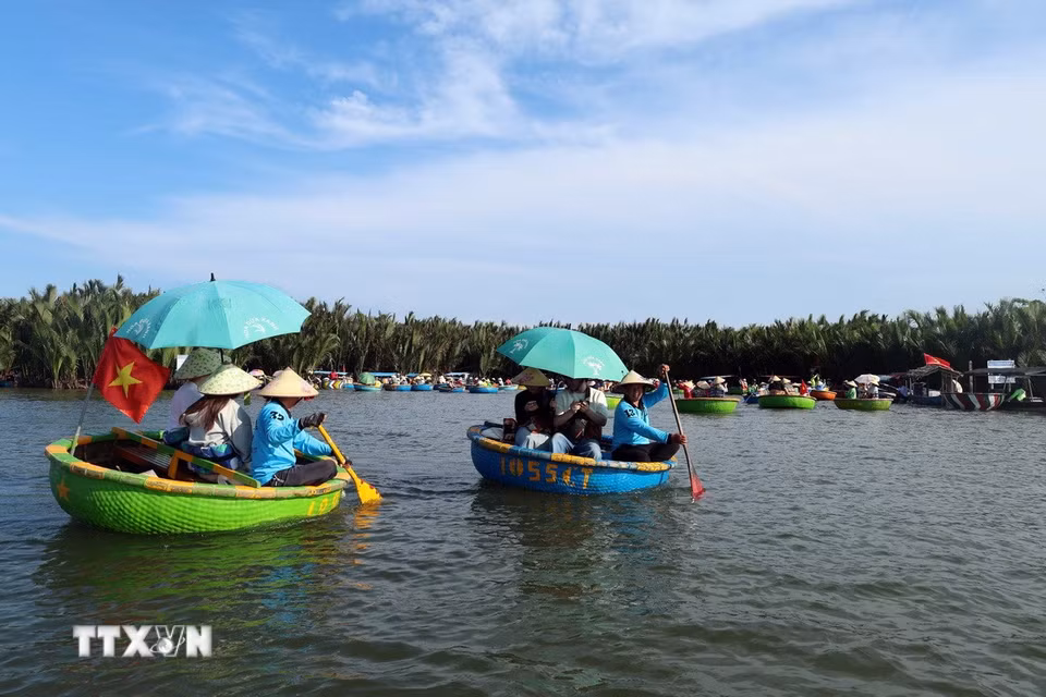 Du khách lênh đênh trên những chiếc thuyền thúng nhỏ khám phá làng dừa Cẩm Thanh, một trong 50 ngôi làng đẹp nhất thế giới năm 2025. (Ảnh: Đỗ Trưởng/TTXVN)