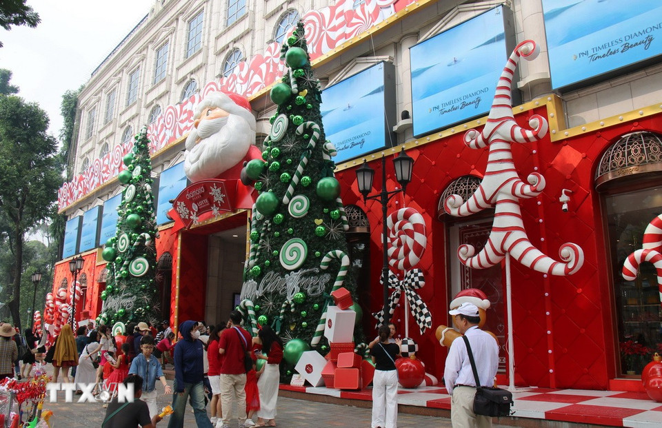 Tiểu cảnh ông già Noel và hai cây thông lớn thu hút người dân TP. Hồ Chí Minh tới tham quan, chụp ảnh. (Ảnh: Thu Hương/TTXVN)