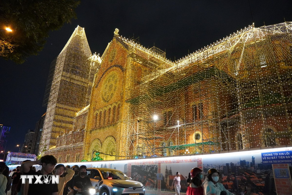 Nhà thờ Đức Bà được thắp sáng bằng 1.000km dây đèn LED, bổ sung nhiều họa tiết như quả địa cầu, ngôi sao, quả chuông dọc mái ngói. (Ảnh: Thu Hương/TTXVN)