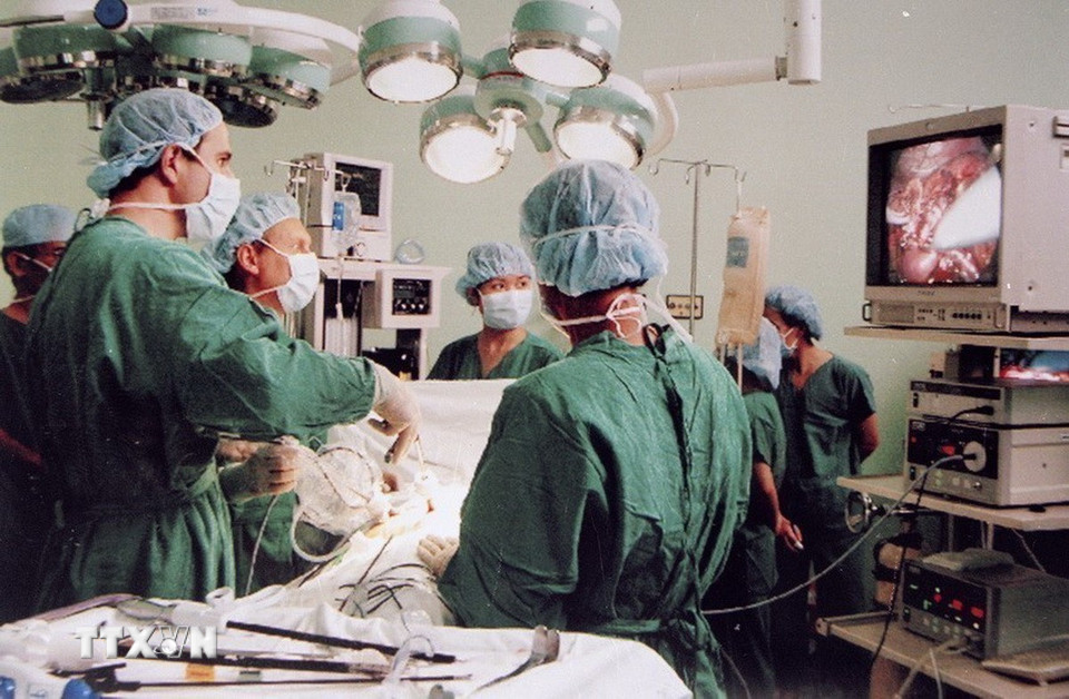 Nhiều kỹ thuật chuyên môn cao được thực hiện thành công tại nhiều bệnh viện trung ương như ghép tạng, nội soi, phẫu thuật bằng robot, chuyển giao một số kỹ thuật cho bệnh viện tuyến tỉnh, huyện...Trong ảnh: Các giáo sư, bác sỹ Viện trường Liege' (Vương quốc Bỉ) và các bác sỹ bệnh viện Nhân dân 115 (TP Hồ Chí Minh) đang thực hiện ca mổ nội soi thận từ người hiến. Đây là ca mổ nội soi ghép thận lần thứ 4 của Viện (2004). (Ảnh: Thế Anh/TTXVN)