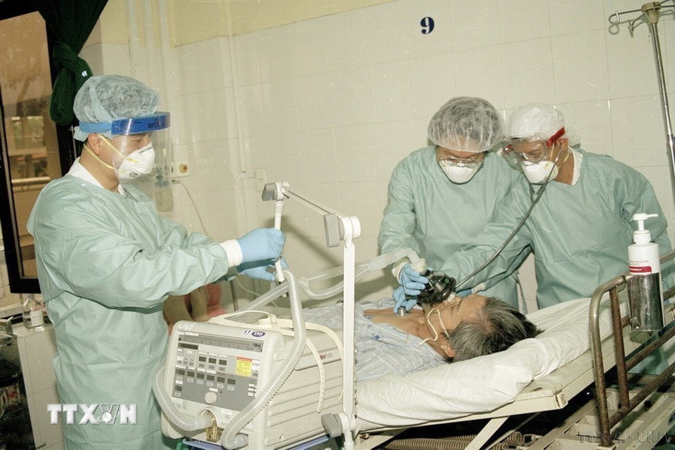 Không chỉ khống chế các dịch bệnh trong nước, Việt Nam là một trong những quốc gia đầu tiên khống chế thành công dịch SARS, cúm A/H5N1, cúm A/H1N1; ngăn chặn thành công không để một số dịch bệnh nguy hiểm mới nổi xâm nhập như cúm A/H7N9, Ebola, MERS-CoV, COVID-19... Trong ảnh: Các bác sĩ Viện Y học Lâm sàng các bệnh nhiệt đới Hà Nội điều trị cho bệnh nhân mắc SARS nặng (2003). (Ảnh: Hữu Oai/TTXVN)