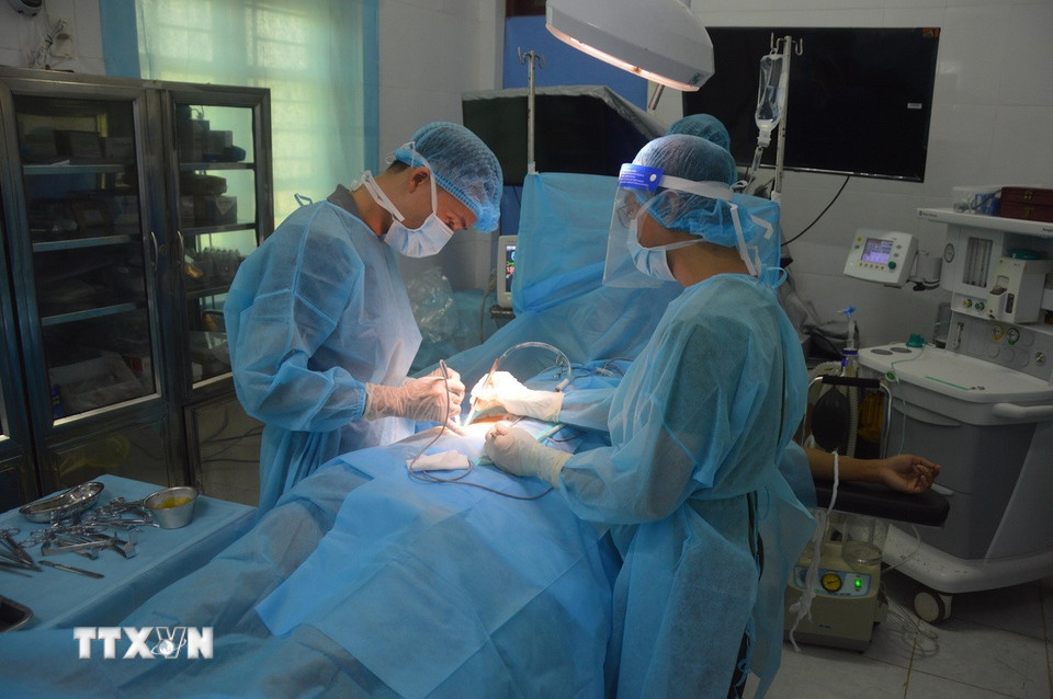 Dù cách trở về mặt địa lý nhưng công tác chăm sóc và bảo vệ sức khỏe cho bộ đội, cán bộ, chiến sỹ nhân dân và ngư dân trên huyện đảo Trường Sa luôn được Đảng, Nhà nước quan tâm và triển khai một cách hiệu quả. Những thầy thuốc nơi đây đã nỗ lực hết mình để đảm bảo sức khỏe cho người dân, đặc biệt là những trường hợp cấp cứu khẩn cấp. Trong ảnh: Bác sỹ tại Bệnh xá quân y đảo Song Tử Tây phẫu thuật cho ngư dân gặp nạn trên biển. (Ảnh: Hữu Quyết/TTXVN)