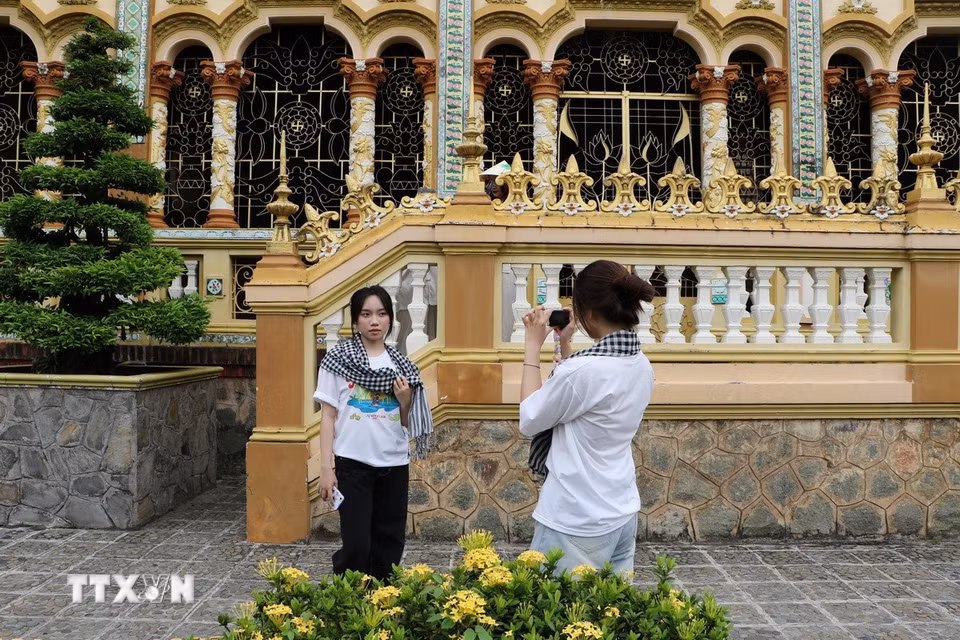Du khách ghi lại hình ảnh lưu niệm tại ngôi chùa gần 200 năm tuổi. (Ảnh: Hồng Thái/TTXVN)