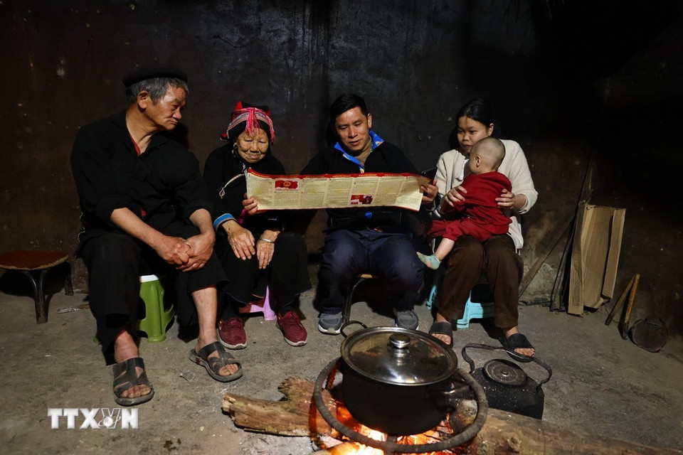 Cán bộ tuyên truyền bầu cử tại nhà dân ở thôn Nặm Đăm, xã Quản Bạ. (Ảnh: Minh Đức/TTXVN)