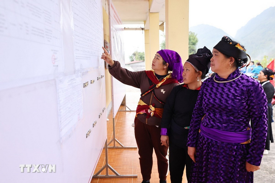 Cử tri xem danh sách ứng cử viên được niêm yết công khai tại nhà văn hóa thôn Nà Chang, xã Quản Bạ. (Ảnh: Minh Đức/TTXVN)