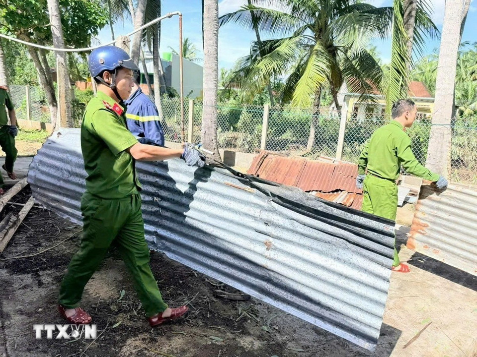 Lực lượng Công an tỉnh Gia Lai giúp người dân lợp lại mái nhà. (Ảnh: Sỹ Thắng/TTXVN)