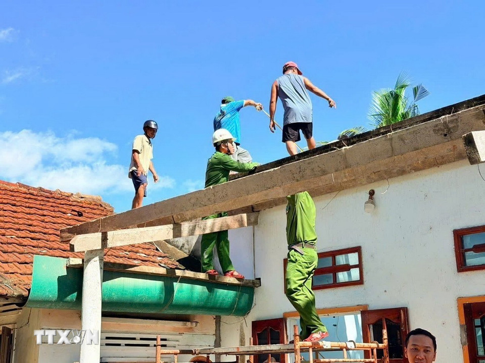 Lực lượng Công an tỉnh Gia Lai giúp người dân lợp lại mái nhà. (Ảnh: Sỹ Thắng/TTXVN)