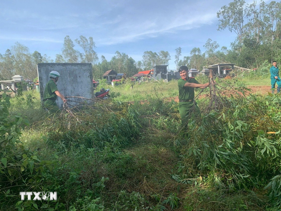 Lực lượng Công an tỉnh Gia Lai giúp người dân dọn dẹp cây cối ngã đổ. (Ảnh: Sỹ Thắng/TTXVN)