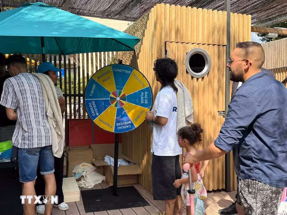 Người dân tham gia các hoạt động trải nghiệm và nhận quà lưu niệm tại khu vực tắm trên sông Marne ở Joinville-le-Pont trong ngày khai trương. (Ảnh: Hữu Chiến/TTXVN)