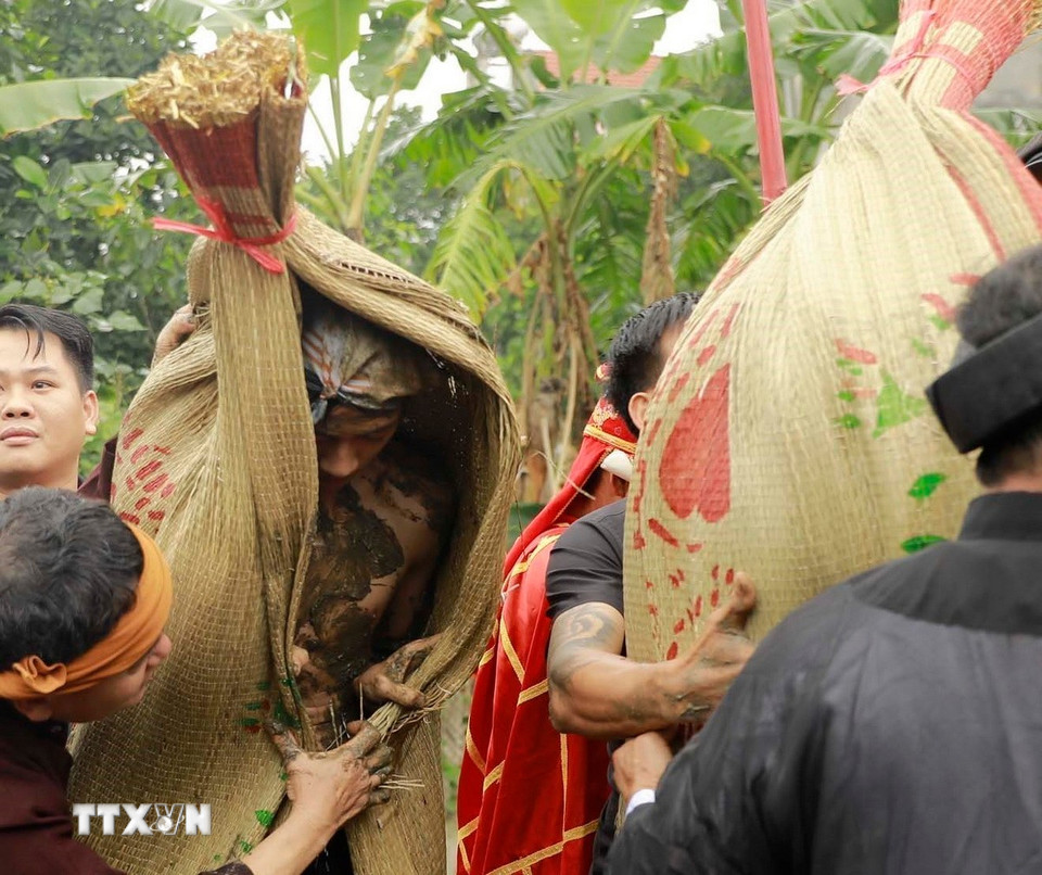 Sau khi thực hiện nghi thức trát bùn các “Bụt” được đội chiếu thánh và rước về đình làng. (Ảnh: Hoàng Hùng/TTXVN)
