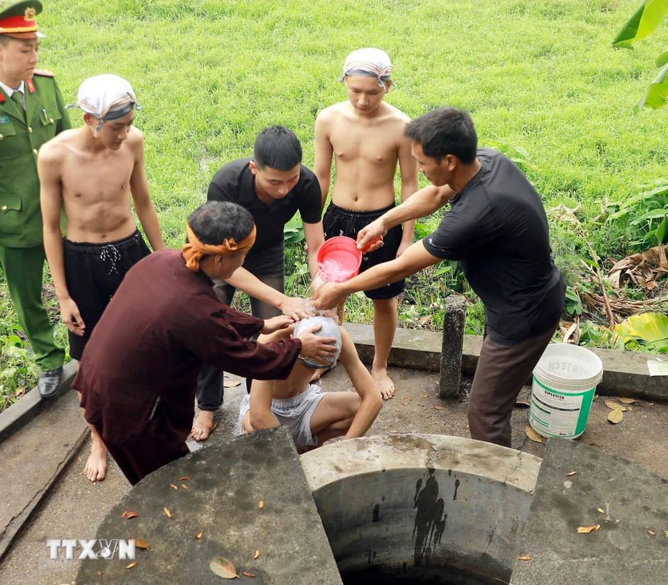 Nghi thức tắm “Bụt” được thực hiện tại giếng cổ của làng. (Ảnh: Hoàng Hùng/TTXVN)