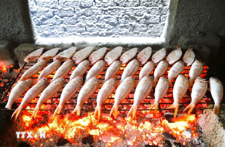 Cá Lưỡng được xếp trên giàn rả được hàn ghép bằng những que sắt nhỏ và nướng trực tiếp trên lửa than hoa. (Ảnh: Xuân Tiến/TTXVN)