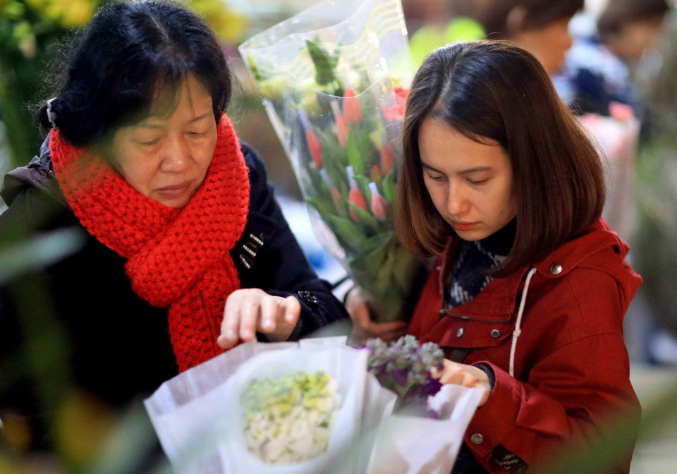 Cùng mẹ dạo chơi chợ hoa đêm Quảng Bá. (Ảnh: Nhật Anh/TTXVN)
