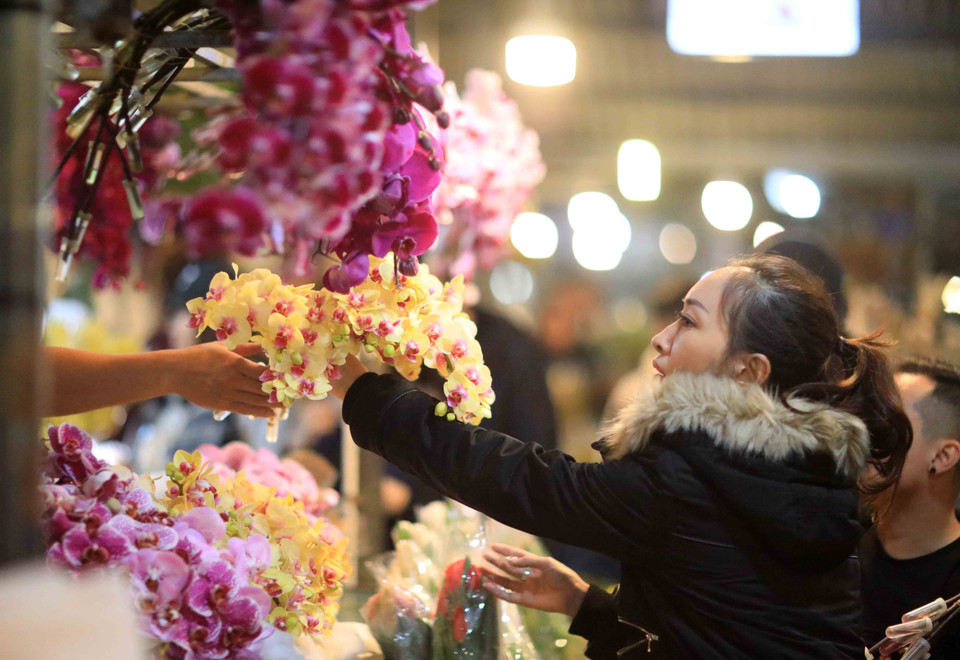 Các bạn trẻ trải nghiệm chợ hoa đêm Quảng Bá. (Ảnh: Nhật Anh/TTXVN)