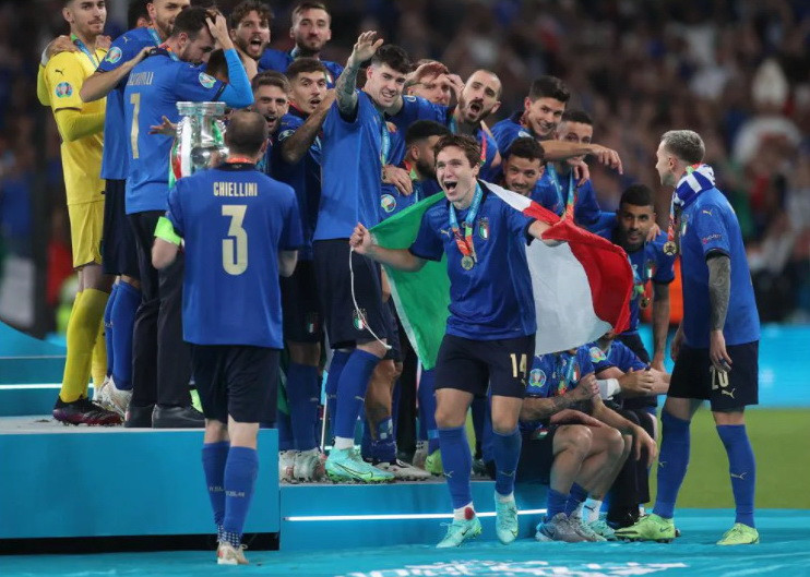 Các cầu thủ nóng lòng khi thủ quân Giorgio Chiellin bê chiếc cúp về bục vinh danh. (Nguồn: UEFA)