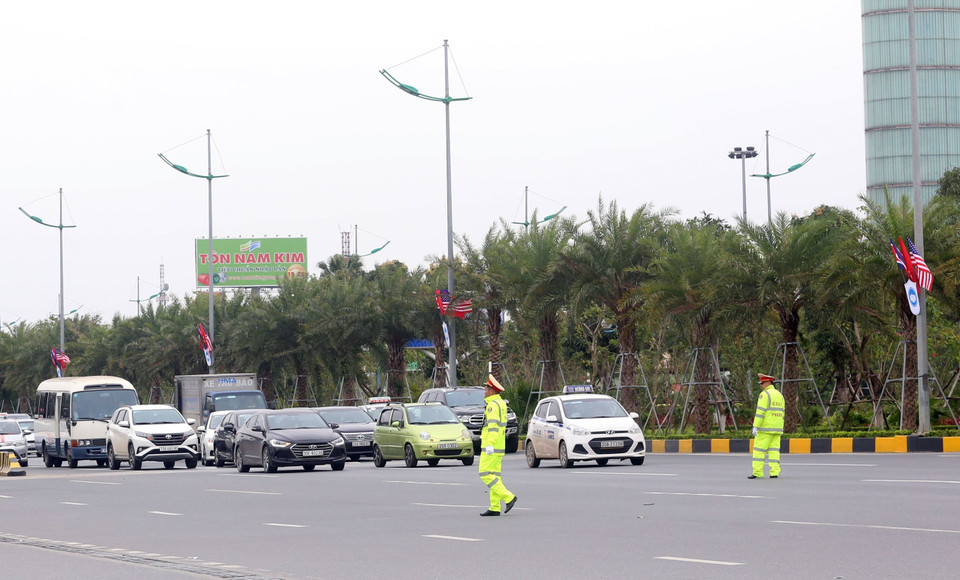 Cảnh sát giao thông tạm dừng các phương tiện để nhường đường cho đoàn xe của phái đoàn Triều Tiên di chuyển từ sân bay quốc tế Nội Bài về trung tâm thủ đô, sáng 24/2. (Ảnh: Huy Hùng/TTXVN)