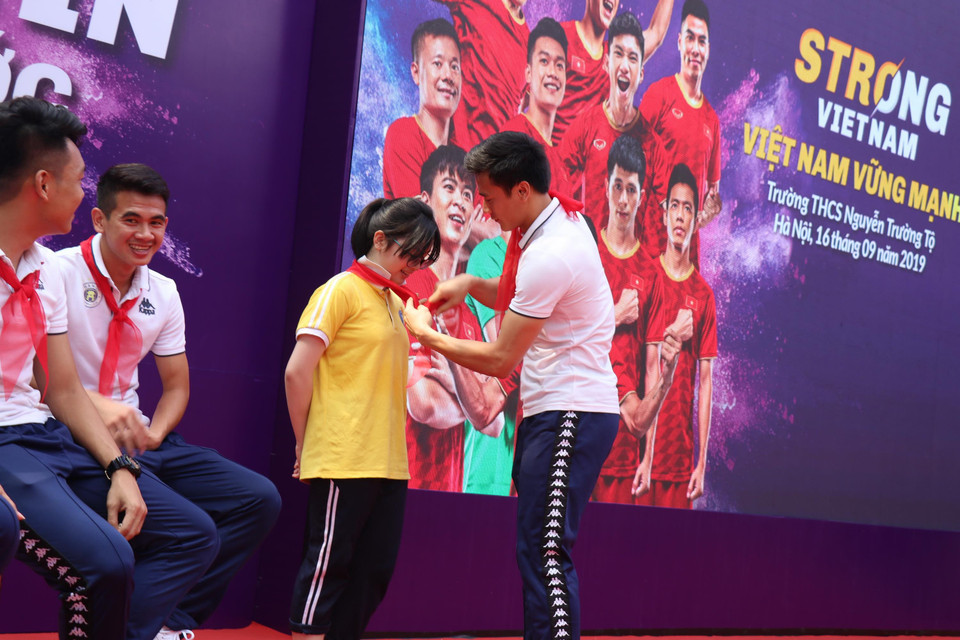 Thủ môn Tiến Dũng sau đó cũng đã có màn đổi khăn quàng đỏ với một nữ sinh. (Ảnh: Phương Trang/Vietnam+)
