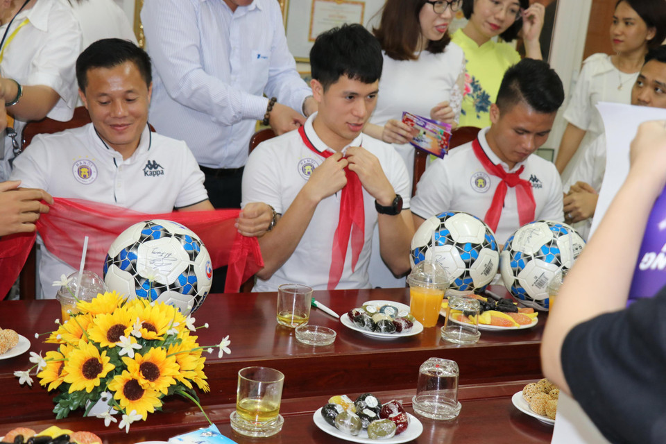 Các cầu thủ Hà Nội FC vui vẻ khi được đeo khăn quàng đỏ... (Ảnh: Phương Trang/Vietnam+)