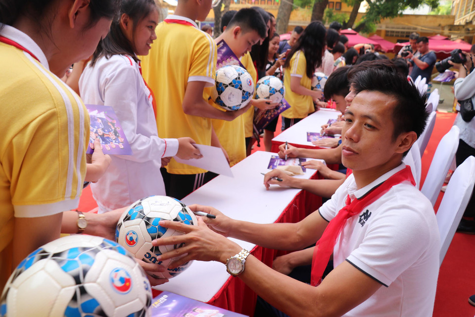 Thủ quân Văn Quyết và các cầu thủ Hà Nội FC sau đó đã ký tặng các học sinh... (Ảnh: Phương Trang/Vietnam+)