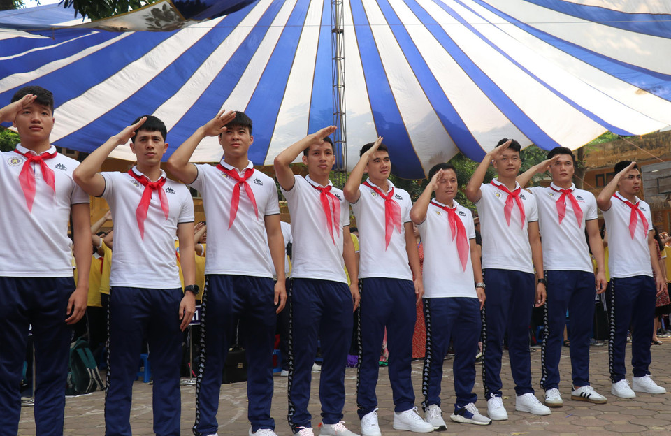 Trước khi diễn ra buổi giao lưu, các cầu thủ và các em học sinh đã thực hiện nghi lễ chào cờ sáng thứ Hai đầu tuần hết sức ý nghĩa. (Ảnh: Phương Trang/Vietnam+)