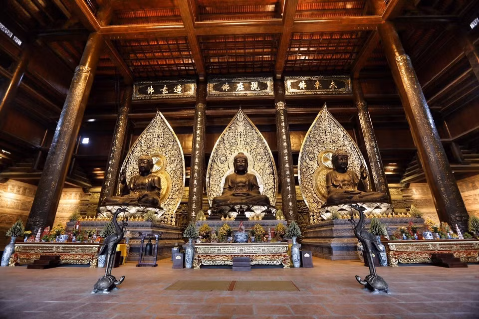 Ba pho tượng Phật bằng đồng dát đồng đen, mỗi bức nặng 200 tấn đặt giữa trung tâm điện Tam Thế. (Ảnh: Trọng Đạt/TTXVN)