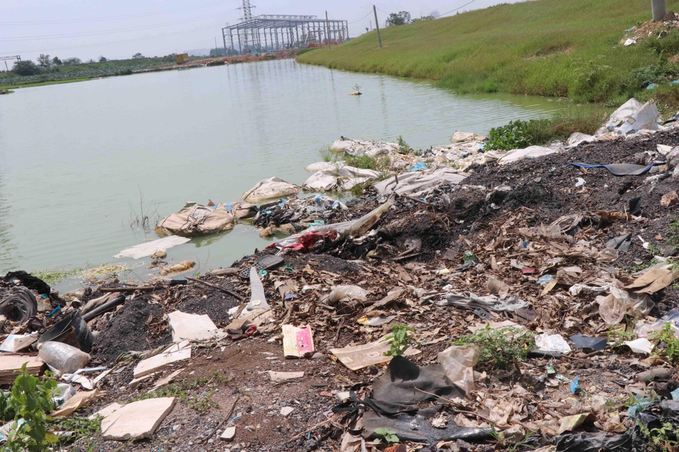 Nhiều bao vải vụn được đổ xuống ao hồ tại thôn Đông Yên, xã Đông Phong, huyện Yên Phong, tỉnh Bắc Ninh. (Ảnh: Thái Hùng/TTXVN)