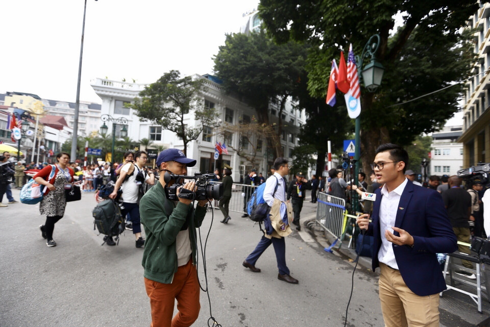Phóng viên trong nước và quốc tế tác nghiệp bên ngoài khu vực cách ly, phía đường Lý Thái Tổ trước quảng trường Cách mạng Tháng Tám. (Ảnh: Minh Quyết/TTXVN)