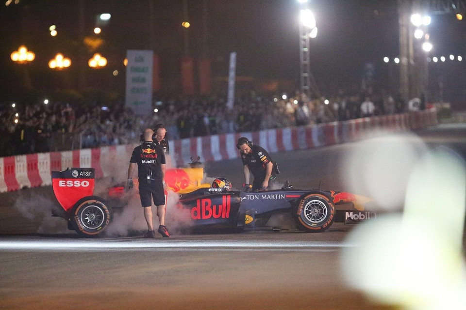 Các kỹ thuật viên đội đua làm nguội động cơ và lốp sau khi xe thực hiện xong những vòng chạy biểu diễn. (Ảnh: Trọng Đạt/TTXVN)