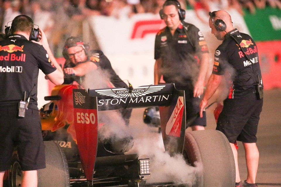 Nhân viên kỹ thuật của đội đua Aston Martin Red Bull làm mát lốp và động cơ sau khi chiếc xe thực hiện xong 3 vòng chạy trên đoạn đường phía trước sân vận động Mỹ Đình. (Ảnh: Trọng Đạt/TTXVN)