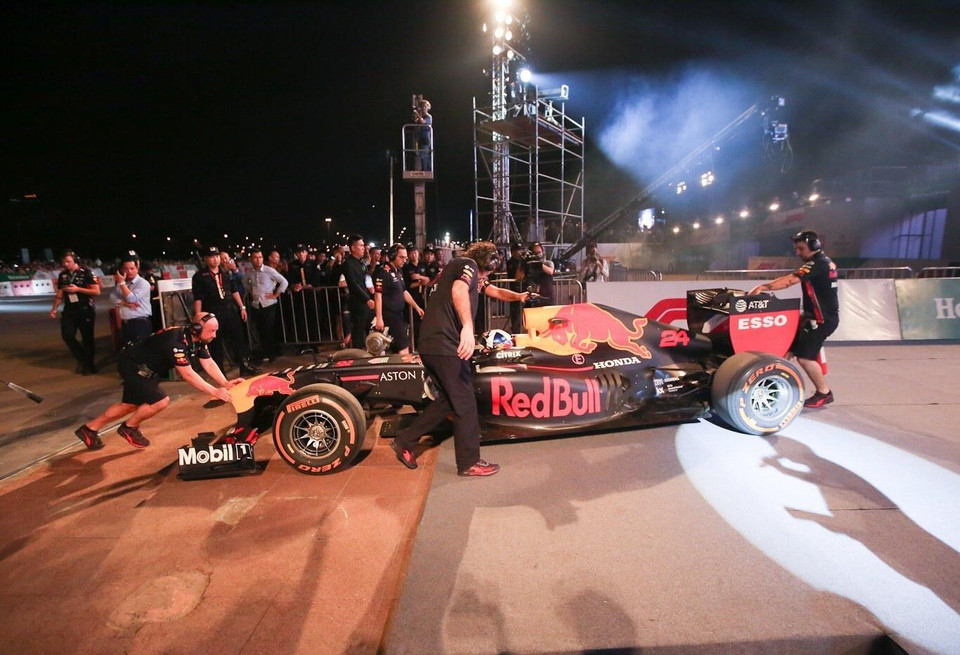 Nhân viên kỹ thuật của đội đua Aston Martin Red Bull đưa xe vào khu vực khán đài. (Ảnh: Trọng Đạt/TTXVN)