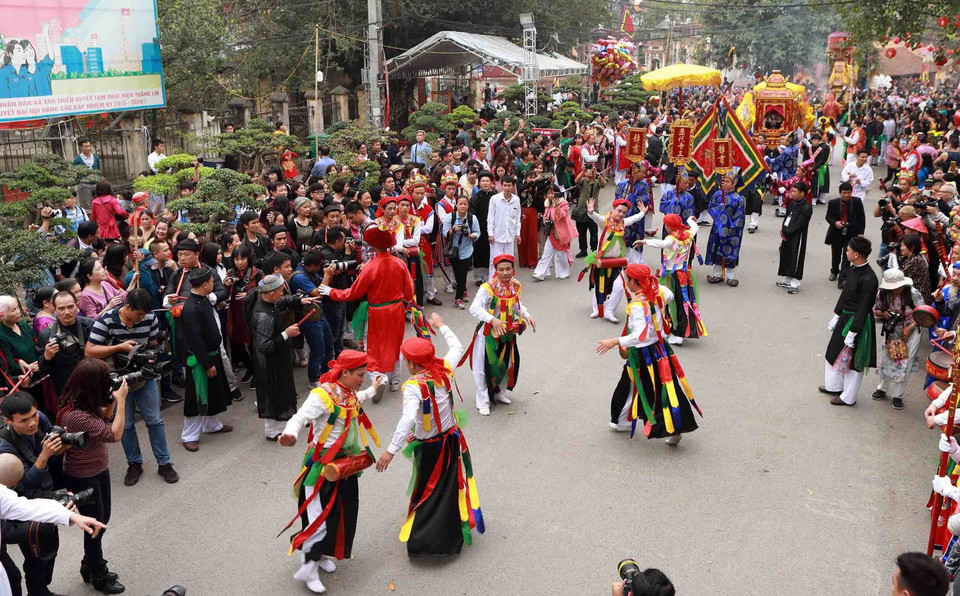 Điệu múa cổ 'Con đĩ đánh bồng' do các chàng trai trong làng Triều Khúc giả gái thực hiện thu hút đông đảo người xem. (Ảnh: Hoàng Hùng/TTXVN)