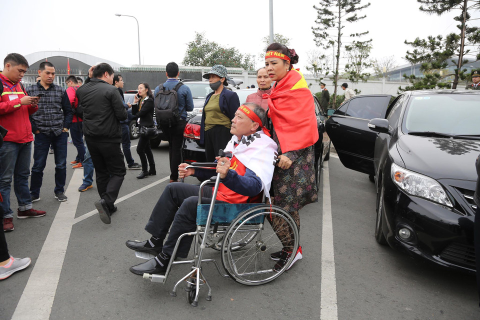 Một cổ động viên ngồi trên xe lăn đón chào đội tuyển. (Ảnh: Minh Sơn/Vietnam+)