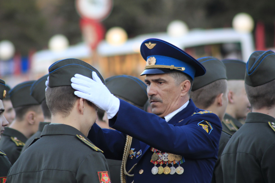 Sỹ quan chỉ huy căn chỉnh trang phục cho chiến sĩ trẻ trong đội diễu binh. (Ảnh: Trần Hiếu/Vietnam+)