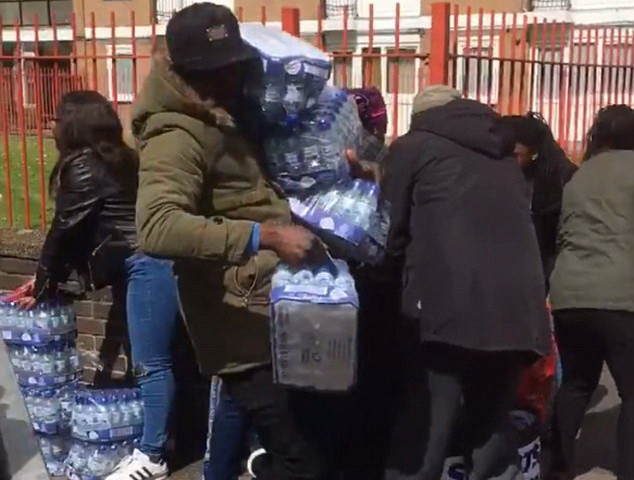 Một người đàn ông đã vác lên mình đến 4 lốc nước. (Nguồn: Daily Mail)