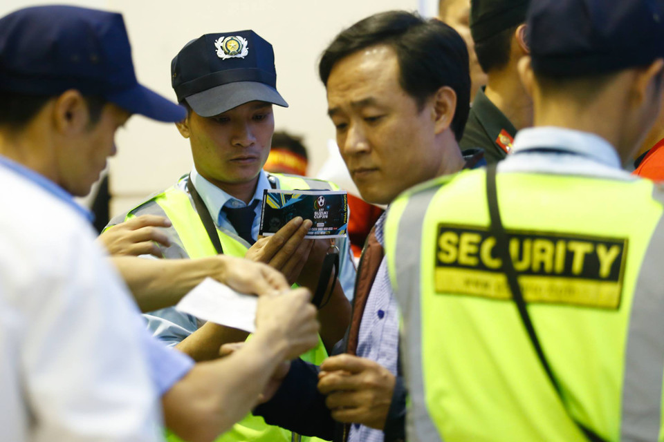 Nhân viên an ninh kiểm tra vé của người hâm mộ vào sân. (Ảnh: Minh chiến/Vietnam+)