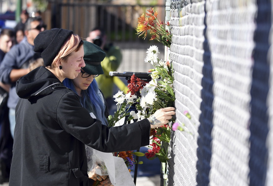 Đặt hoa tưởng niệm các nạn nhân sau vụ hỏa hoạn. (Nguồn: AP/TTXVN)