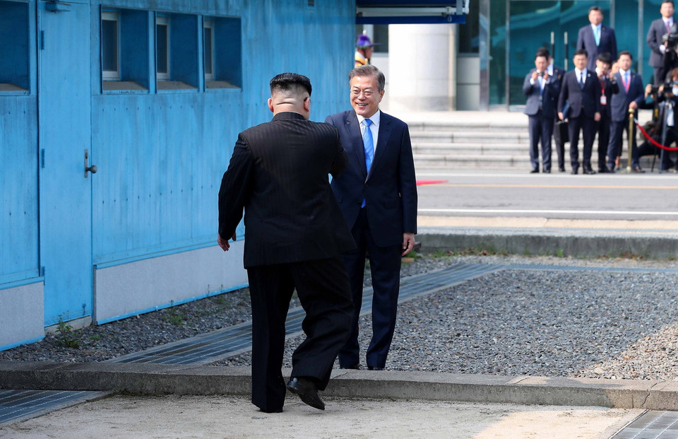 Tổng thống Hàn Quốc Moon Jae-in đón Nhà lãnh đạo Triều Tiên Kim Jong-un (trái) tại đường phân định ranh giới hai miền ở làng đình chiến Panmunjom. (Nguồn: YONHAP/TTXVN)