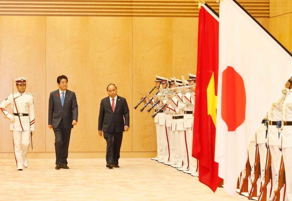 Thủ tướng Nguyễn Xuân Phúc và Thủ tướng Nhật Bản Shinzo Abe duyệt đội danh dự tại lễ đón. (Ảnh: Thống Nhất/TTXVN)