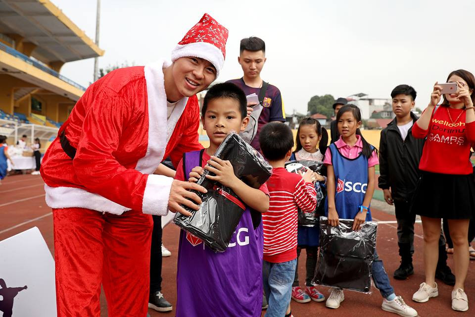 Hậu vệ Duy Mạnh trao quà và chụp ảnh lưu niệm cùng các em nhỏ.