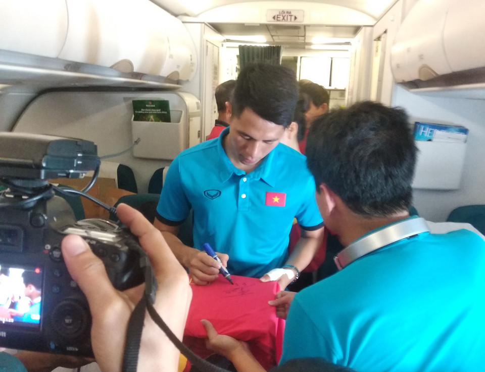 ...và ký cho các cổ động viên cùng chuyến bay của Vietnam Airlines về Hà Nội. (Ảnh: Việt Nam+)