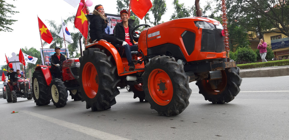 Cổ động viên lái máy cày diễu phố tại đường Hoàng Quốc Việt (Cầu Giấy). (Ảnh: Nguyễn Thắng/TTXVN)