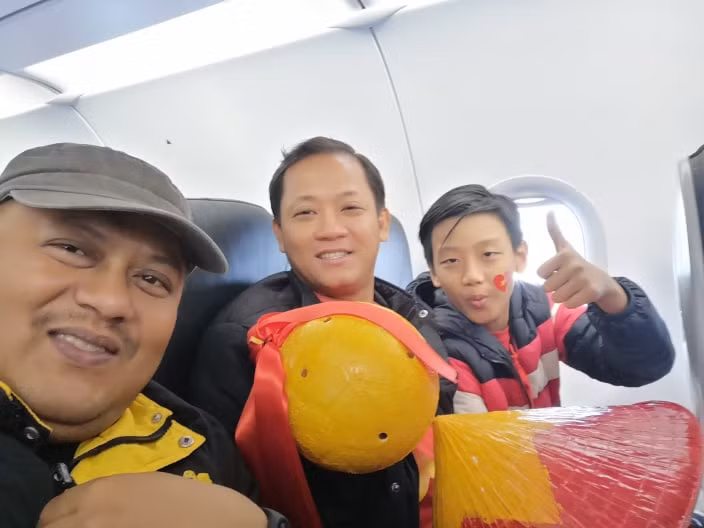Cổ động viên Việt Nam và Malaysia chụp ảnh lưu niệm trên máy bay. (Ảnh: Vietnam+)