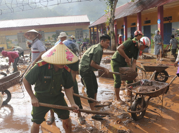 Các chiến sỹ Công an chung tay khắc phục hậu quả mưa lũ tại Trường PTDT Bán trú tiểu học Chà Nưa, Điện Biên. (Ảnh: Xuân Tư/TTXVN)