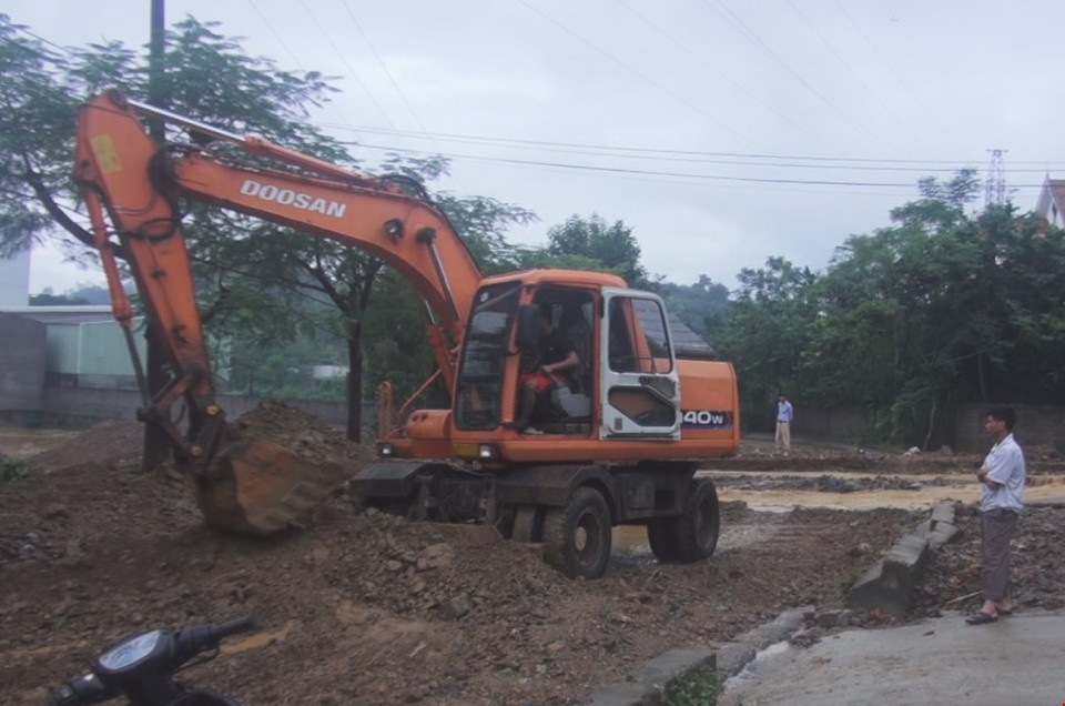 Lực lượng chức năng cùng người dân khẩn trương khắc phục thiệt hại do mưa lũ gây ra. (Ảnh: Thanh Hải/TTXVN)