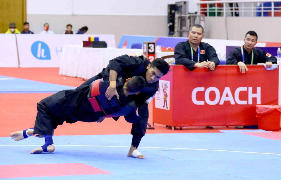 Pha bắt chân và đánh ngã đối phương ghi 3 điểm của vận động viên Trần Đình Nam (Việt Nam-đỏ). (Ảnh: Quang Quyết/TTXVN)