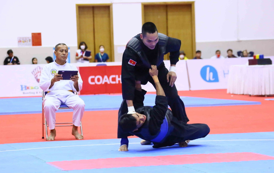 Pha bắt chân và đánh ngã đối phương ghi 3 điểm của vận động viên Trần Đình Nam (Việt Nam-đỏ). (Ảnh: Quang Quyết/TTXVN)